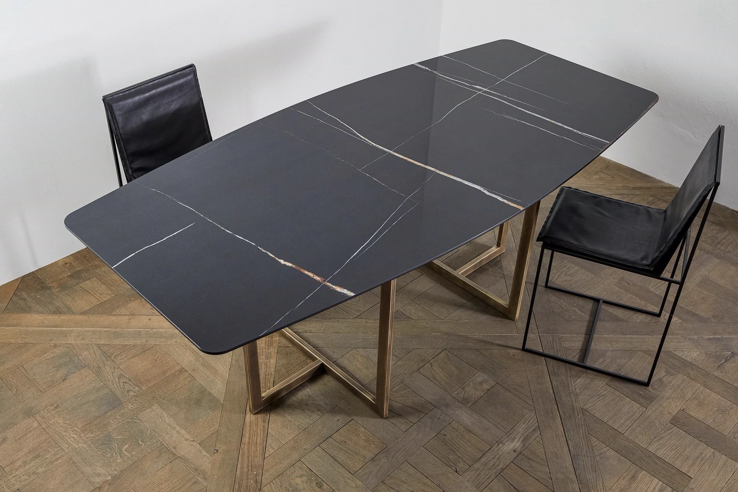 Tavolo con piano in gres nero venato, base in ottone brunito