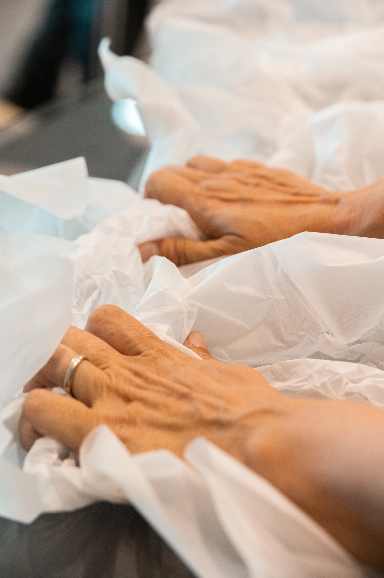 Le mani che stendono il telo di protezione sulla lastra